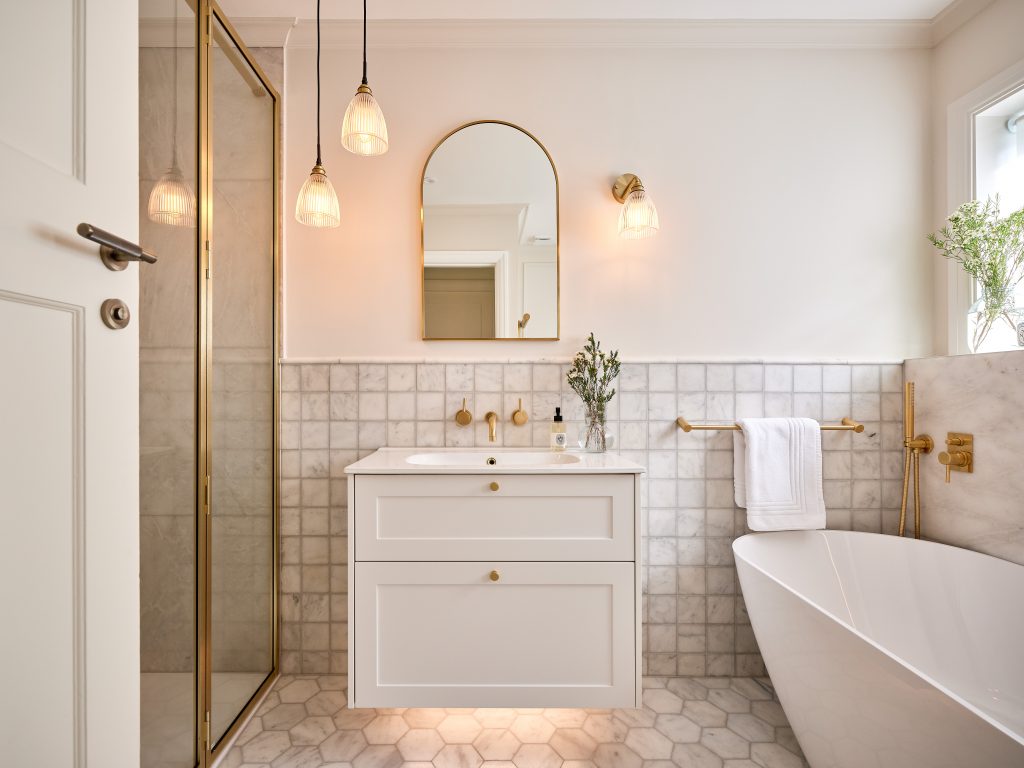 Image of cream bathroom with basin with draws underneath and shower to the side